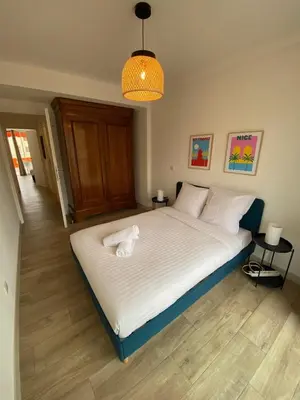 a bedroom with a large bed with white sheets at Magnifique T3, spacieux, lumineux et traversant in Nice
