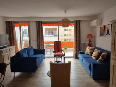a living room with blue couches and a television at Magnifique T3, spacieux, lumineux et traversant in Nice