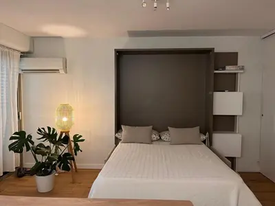 a bedroom with a large bed with a large headboard at Beautiful studio - Terrace in Nice