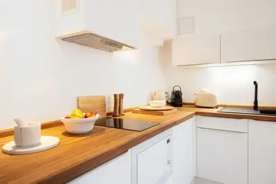 a kitchen with white cabinets and a wooden counter top at #30 Old Town, Castle panoramic View / Terrace & AC in Nice