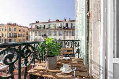 a table on a balcony with a coffee cup and a plant at 7 FOCH 202 - Studio contemporain en plein coeur de Nice - climatisation in Nice