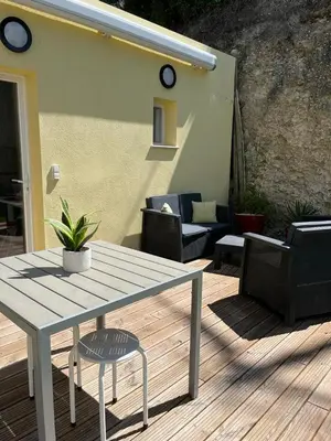 a wooden table and chairs on a wooden deck at Petite maison, cosy, sur les collines niçoises in Nice