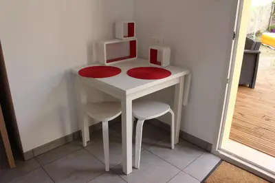 a small white table with two chairs and a microwave at Petite maison, cosy, sur les collines niçoises in Nice