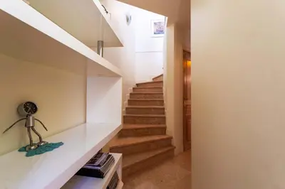 a staircase in a house with white walls and wooden stairs at LA CASA AP4409 By Riviera Holiday Homes in Villefranche-sur-Mer