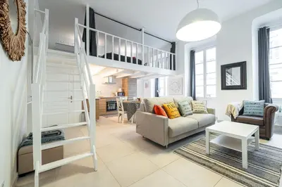 a living room with a loft bed and a couch at La Petite Chaise Bleue Appartement classe 3 etoiles in Nice