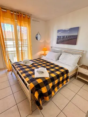 a bedroom with a large bed with a checkered blanket at Suite DES DOMES FSHH in Nice