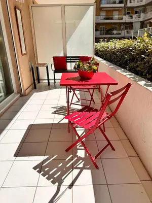 a red table and chairs sitting on a patio at Suite DES DOMES FSHH in Nice