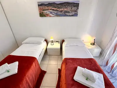 two beds in a small room with two lamps at Suite DES DOMES FSHH in Nice