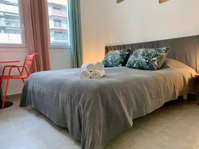 a bedroom with a bed with towels on it at ApartHotel Riviera - MAISON DU GRAND SUD - Confortable petit 3 pièces - Promenade des Anglais in Nice