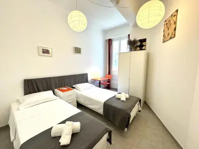 a bedroom with two beds and a table in it at ApartHotel Riviera - MAISON DU GRAND SUD - Confortable petit 3 pièces - Promenade des Anglais in Nice