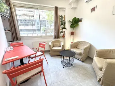 a living room with a red table and chairs at ApartHotel Riviera - MAISON DU GRAND SUD - Confortable petit 3 pièces - Promenade des Anglais in Nice