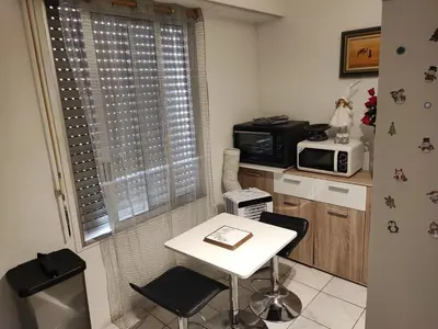 a small kitchen with a table and a microwave at Beau studio meublé hyper centre Nice in Nice