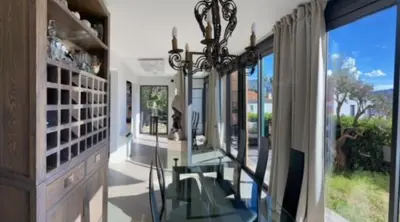 a dining room with a glass table and some windows at Rez de jardin avec vue mer à saint jean in Saint-Jean-Cap-Ferrat