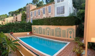 a swimming pool in front of a building at Rez de jardin avec vue mer à saint jean in Saint-Jean-Cap-Ferrat
