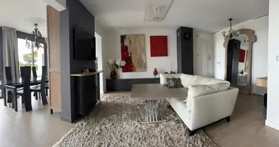 a living room with a white couch and a table at Rez de jardin avec vue mer à saint jean in Saint-Jean-Cap-Ferrat
