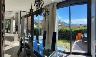 a room with a glass table and a large window at Rez de jardin avec vue mer à saint jean in Saint-Jean-Cap-Ferrat