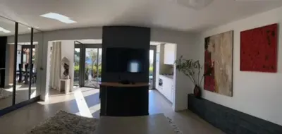 a living room with a flat screen tv on the wall at Rez de jardin avec vue mer à saint jean in Saint-Jean-Cap-Ferrat