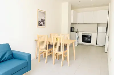 a living room with a dining room table and a blue couch at 1 bedroom Brand new flat in the heart of Nice quartier des Musiciens in Nice