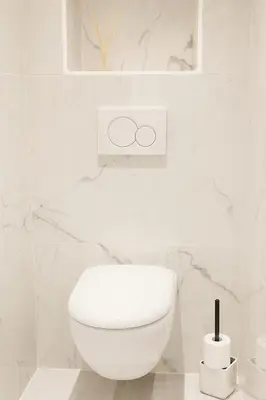 a white toilet in a white bathroom with marble walls at 1 bedroom Brand new flat in the heart of Nice quartier des Musiciens in Nice