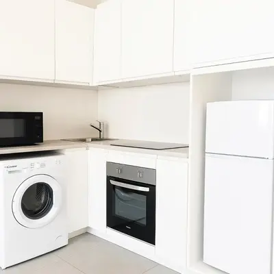 a kitchen with a washing machine and a microwave at 1 bedroom Brand new flat in the heart of Nice quartier des Musiciens in Nice