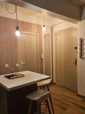 a kitchen with a counter and a bar with two stools at Le plein ciel Studio in Nice