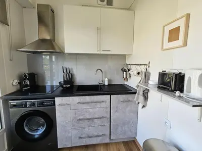 a kitchen with a sink and a washing machine at Le plein ciel Studio in Nice