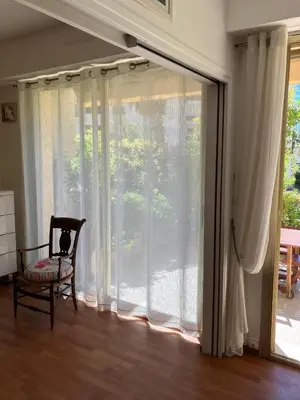a room with a sliding glass door with a chair at Beaulieu in Beaulieu-sur-Mer