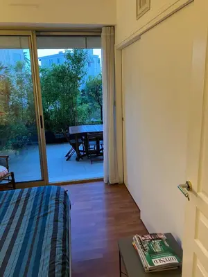 a bedroom with a bed and a sliding glass door with a table at Beaulieu in Beaulieu-sur-Mer