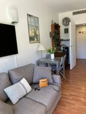 a living room with a gray couch and a table at Beaulieu in Beaulieu-sur-Mer