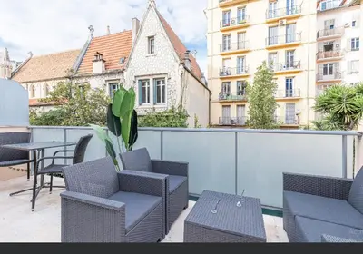 a balcony with chairs and a table and buildings at Beau deux pièces cozy avec terrasse n11 in Nice