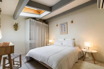 a bedroom with a large white bed and two lamps at 3 pièces au cœur du carré d'or in Nice