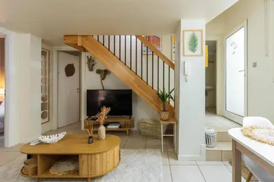 a living room with a staircase and a tv at 3 pièces au cœur du carré d'or in Nice