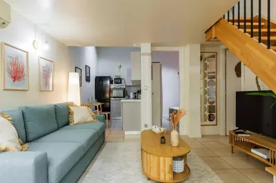 a living room with a blue couch and a tv at 3 pièces au cœur du carré d'or in Nice