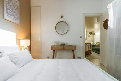 a bedroom with a white bed and a table at 3 pièces au cœur du carré d'or in Nice