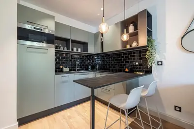 a kitchen with white cabinets and a table and chairs at MY CASA - GUIDONI - Superb City Center Suite Apartment in Nice