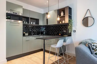 a kitchen with white cabinets and a counter with stools at MY CASA - GUIDONI - Superb City Center Suite Apartment in Nice