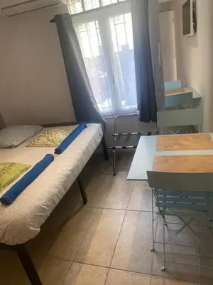 a room with a bed and a desk and a table at Appartement Nice proche de Monaco in Nice