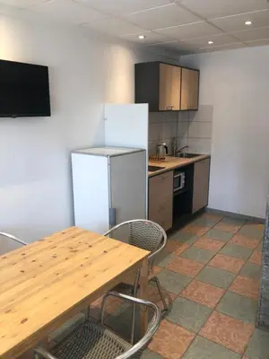 a kitchen with a wooden table and a refrigerator at Appartement Nice proche de Monaco in Nice