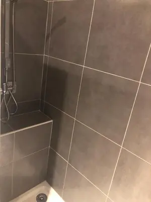 a bathroom with a shower with gray tiles at Appartement Nice proche de Monaco in Nice