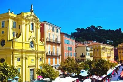 a yellow building with a clock on it in a city at Sublime appartement 4P classé dans le Vieux-Nice in Nice