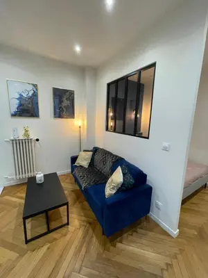 a living room with a blue couch and a table at Appart Cosy, Proche Gare in Nice