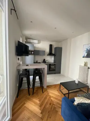 a kitchen and living room with a table and chairs at Appart Cosy, Proche Gare in Nice