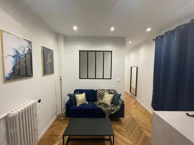 a living room with a blue couch and blue curtains at Appart Cosy, Proche Gare in Nice