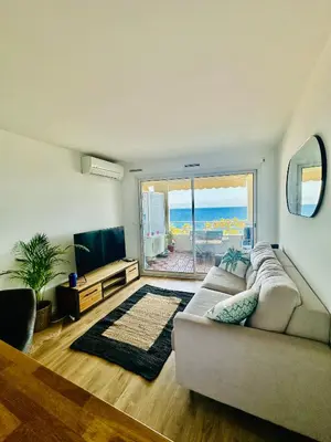 a living room with a couch and a view of the ocean at Cote d’Azur Charm, Studio Apartment with panoramic seaview in Nice in Nice