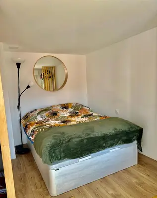a bed in a room with a round mirror at Cote d’Azur Charm, Studio Apartment with panoramic seaview in Nice in Nice