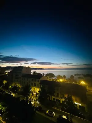 a view of a city at night at Cote d’Azur Charm, Studio Apartment with panoramic seaview in Nice in Nice