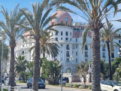 a group of palm trees in front of a building at Royal Studio Massena in Nice