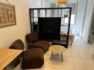 a living room with a tv and chairs and a table at STUDIO REFAIT A NEUF CENTRE DE NICE in Nice