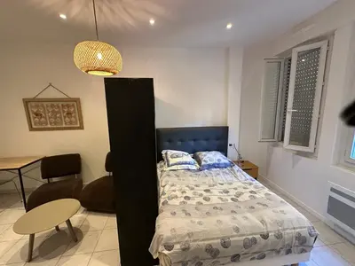 a bedroom with a bed and a table and a chair at STUDIO REFAIT A NEUF CENTRE DE NICE in Nice