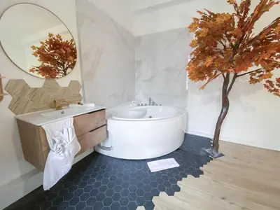 a bathroom with a white tub and a tree in it at Hotel Les Orangers in Nice